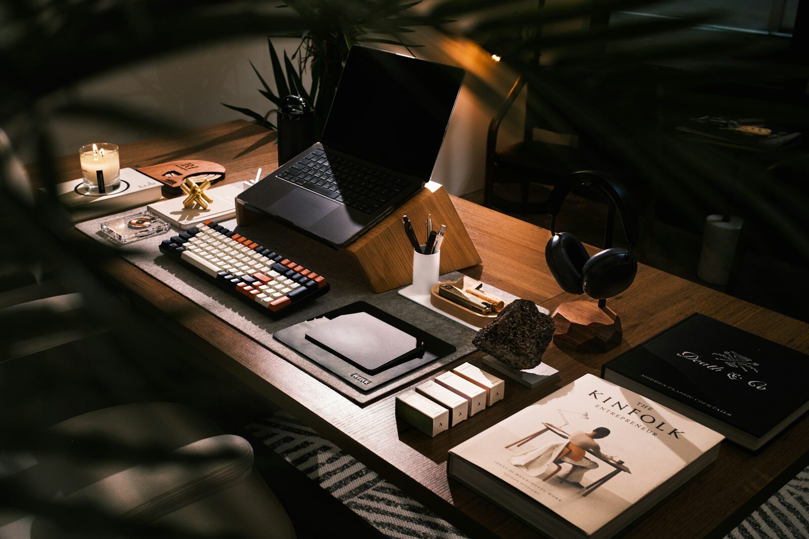 A modern desk setup with a laptop and a stack of books